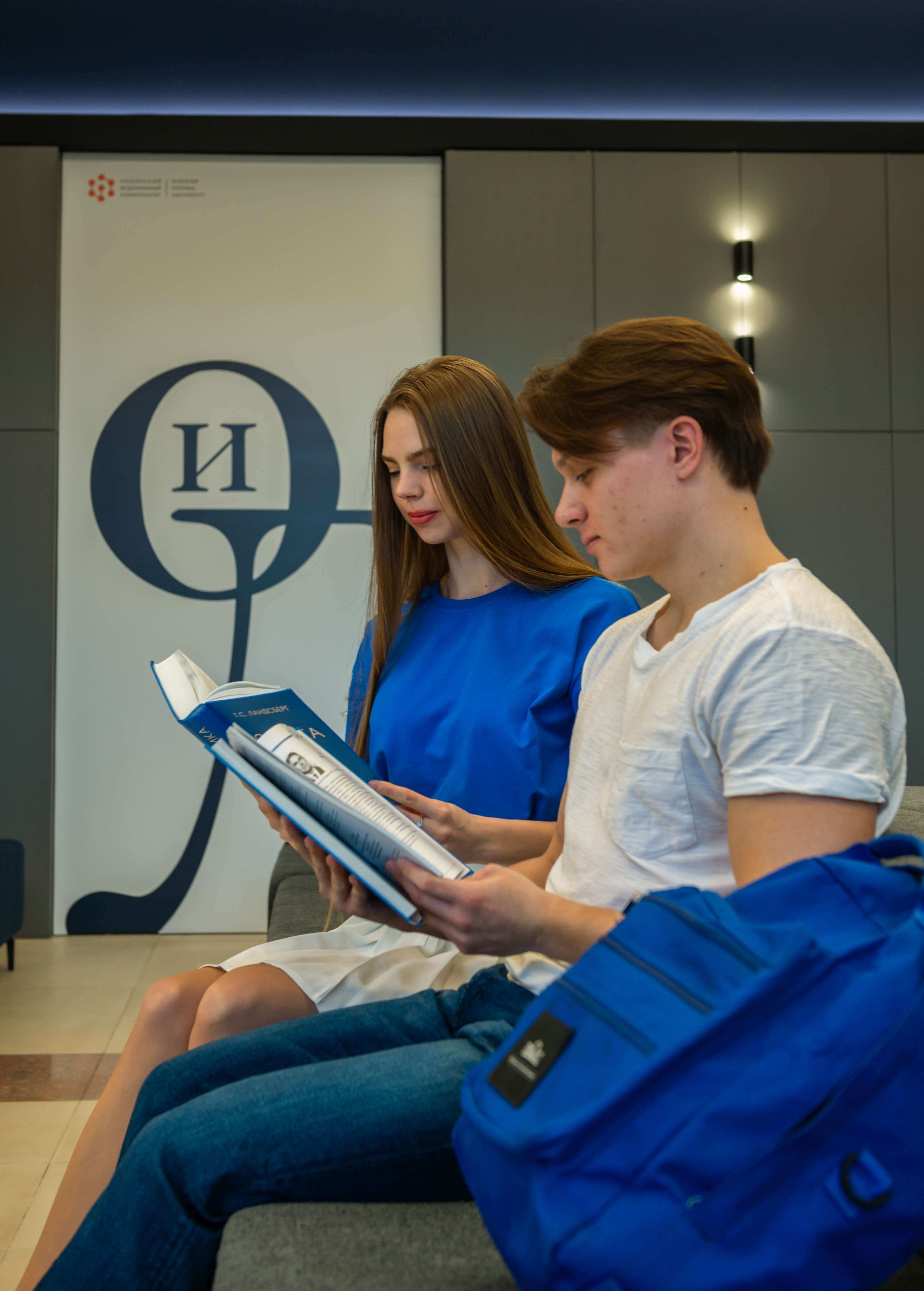 Студенты читают книгу в библиотеке